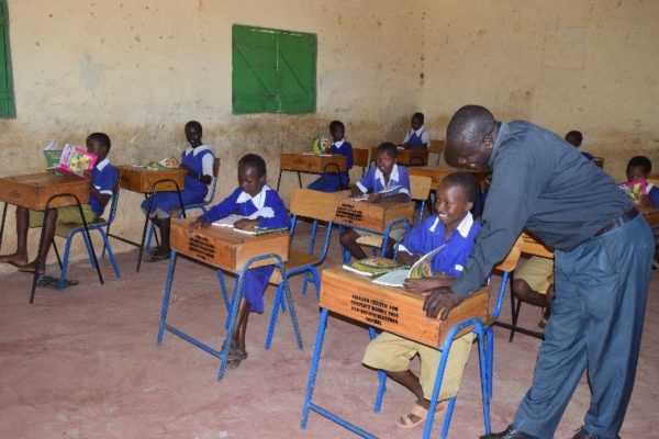 Shalom’s Arthur Magero, M.A., engaging Morijo Primary School pupils to assess the usage of Shalom’s funded textbooks and desks